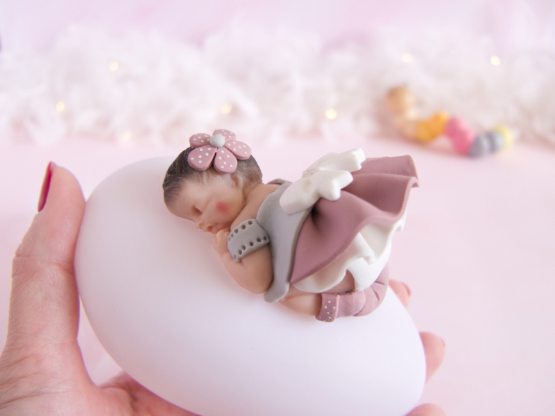 veilleuse bébé fille rose antique, gris et blanc tenue dans la main