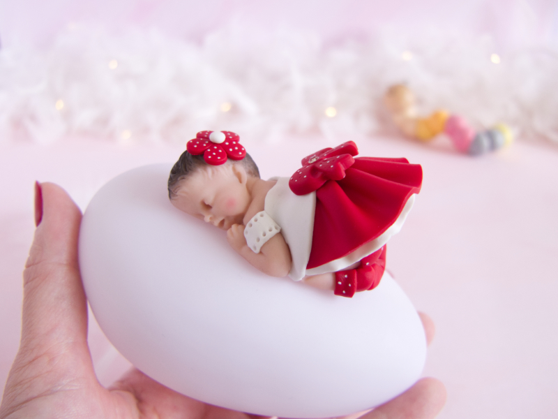 veilleuse bébé fille rouge et blanc tenue dans la main